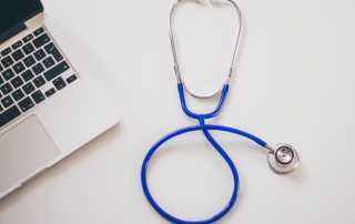 laptop computer and stethoscope to diagnose issues