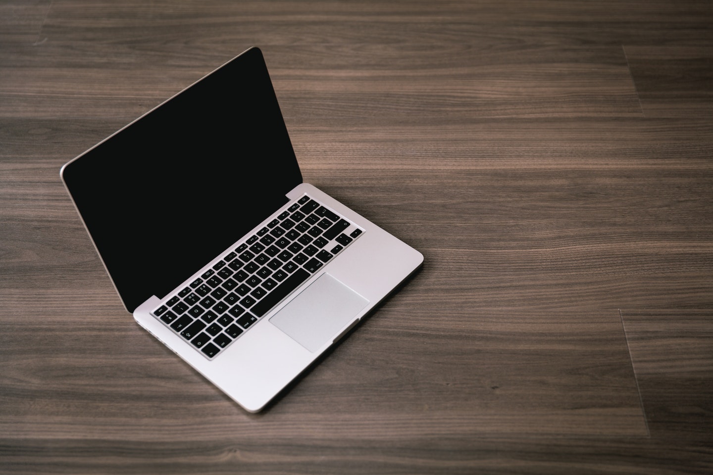 MacBook laptop on brown desk